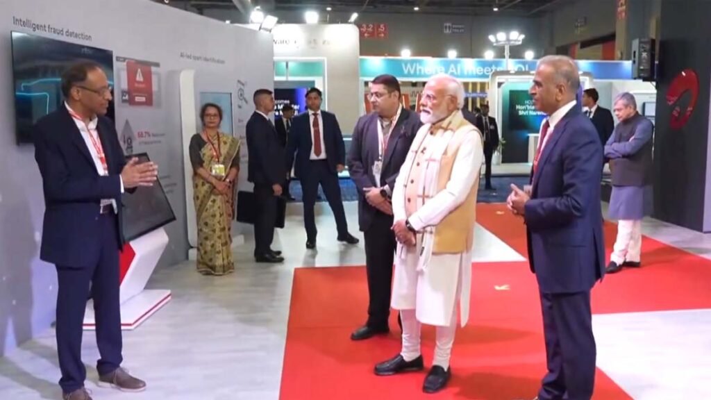 from the India AI Impact Summit 2026 with high-tech displays in the background.